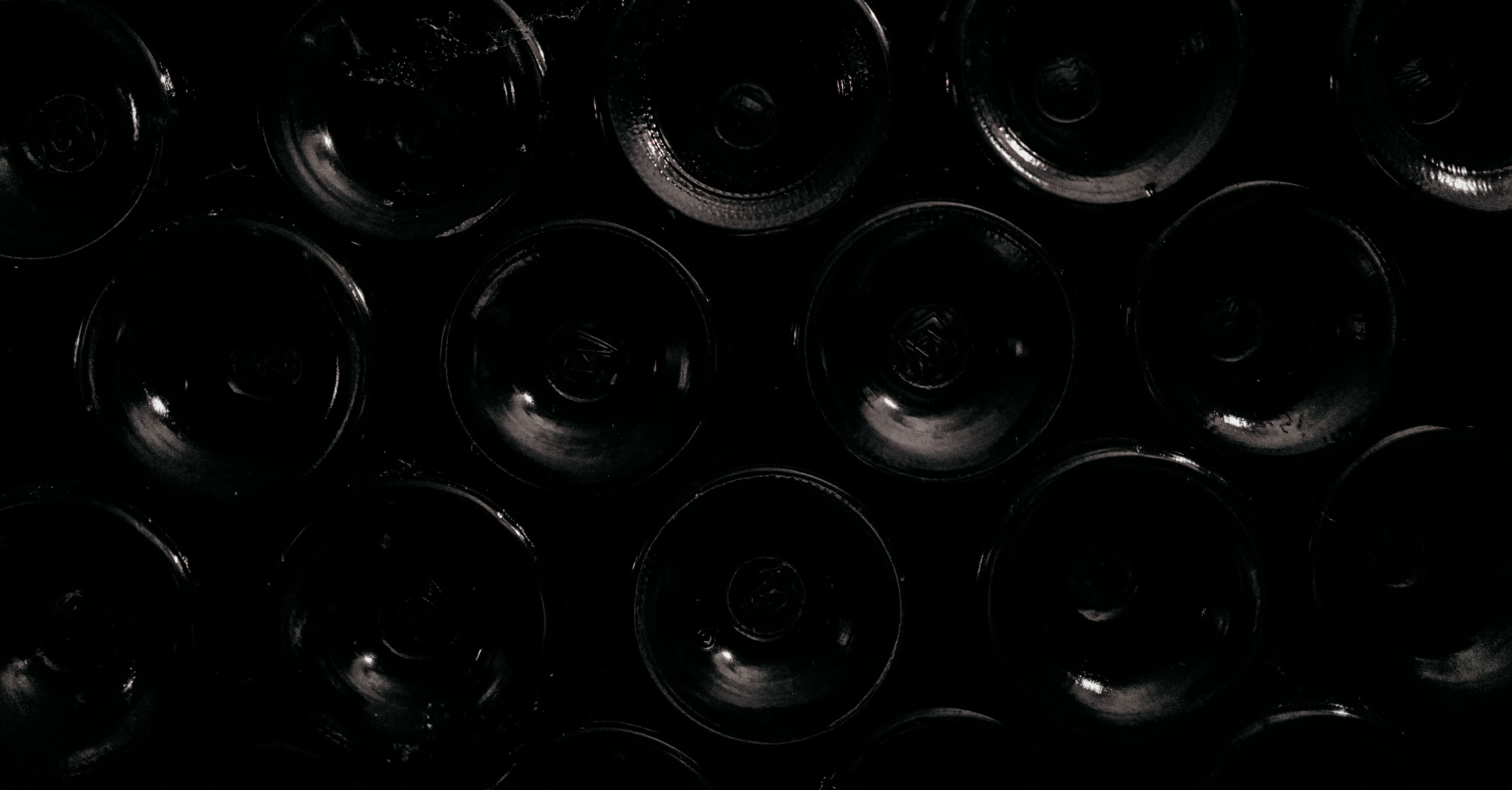 Bottles of old vintages of Brane-Cantenac lying on their side in a wine cellar.